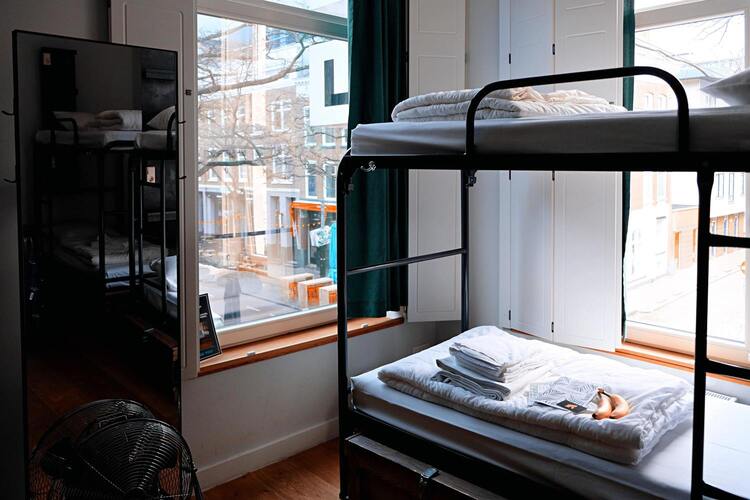 Chambre avec un lit superposé avec une fenêtre vu sur la ville.